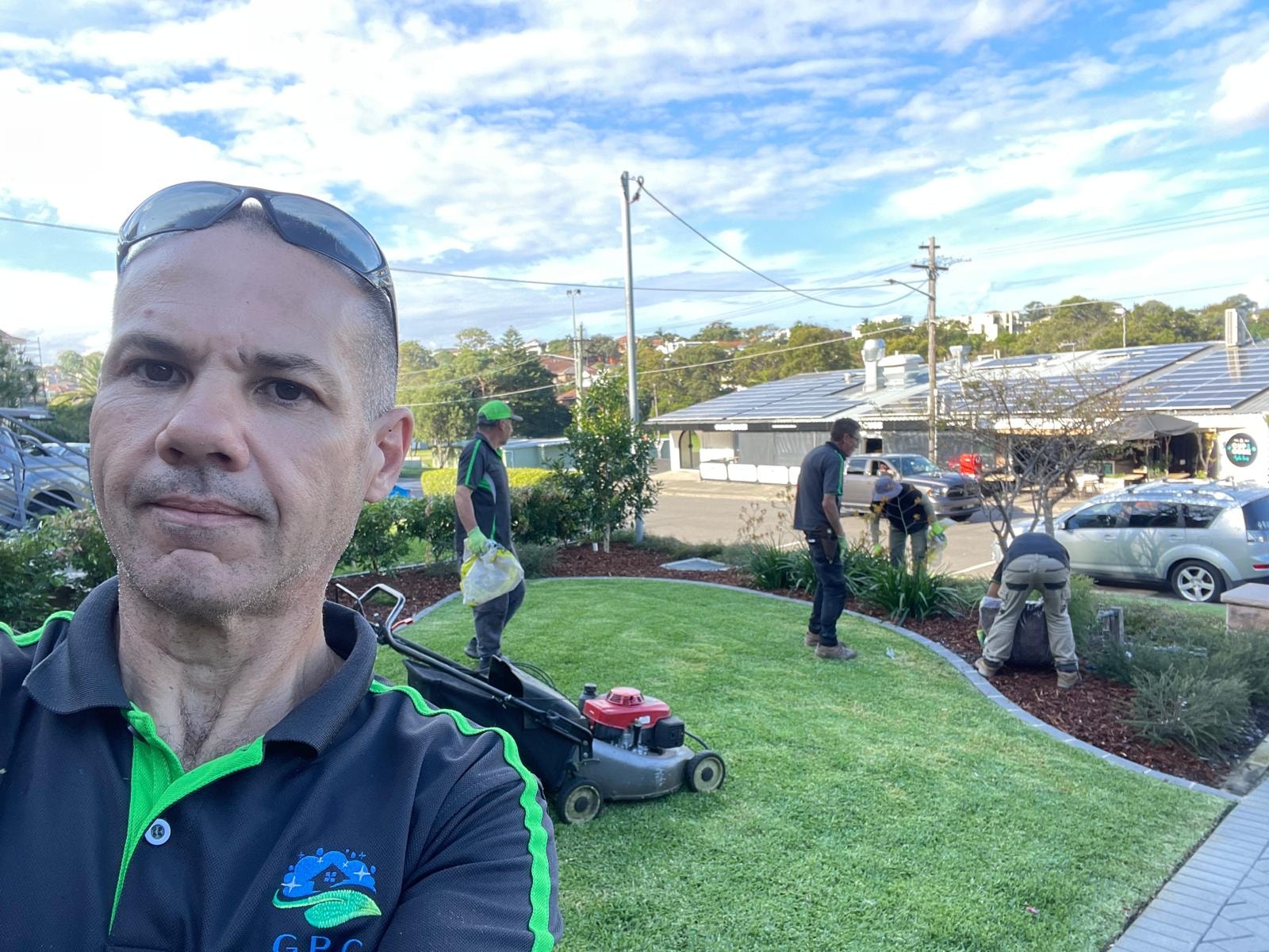 GPC Landscapes team leader selfie with crew maintaining commercial lawn and garden beds