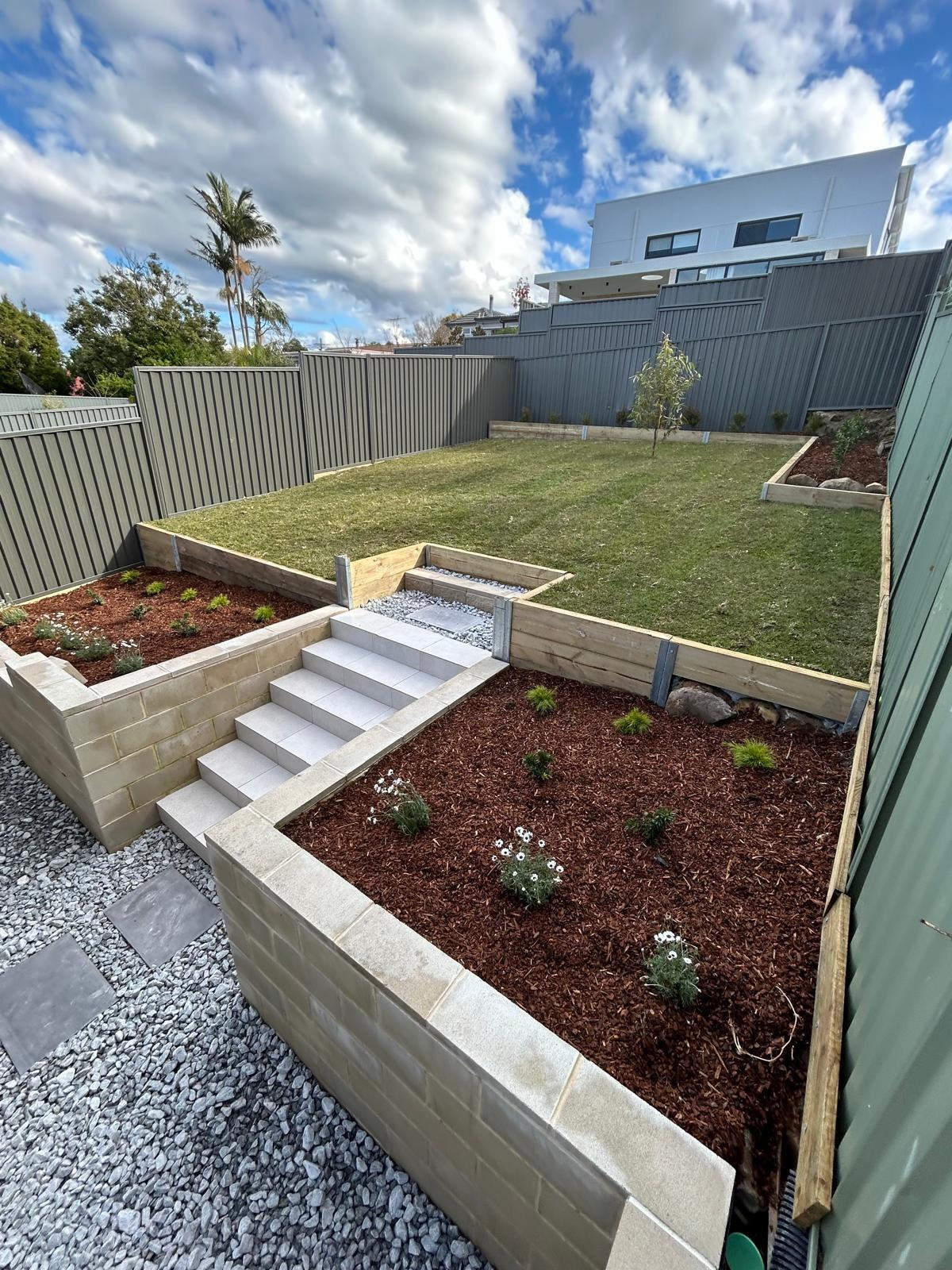 Tiered retaining wall garden with sandstone blocks and timber sleepers